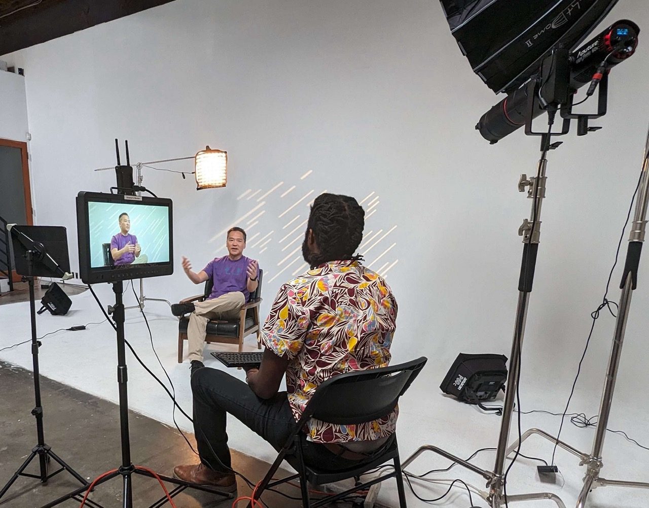 A studio interview being recorded, lights and monitor in frame