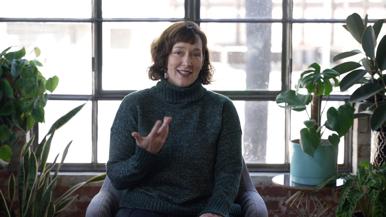 A participant mid-sentence during an interview, talking with her hands